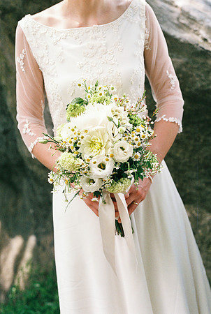 hands of the bride with the bouquet of wedding flowers in her ha