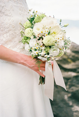 hands of the bride with the bouquet of wedding flowers in her ha