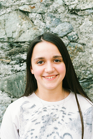 portrait of an 11 year old girl, a wall of pebbles as a backgrou