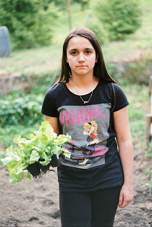 portrait of teenager with salad seedling in hand in the vegetabl