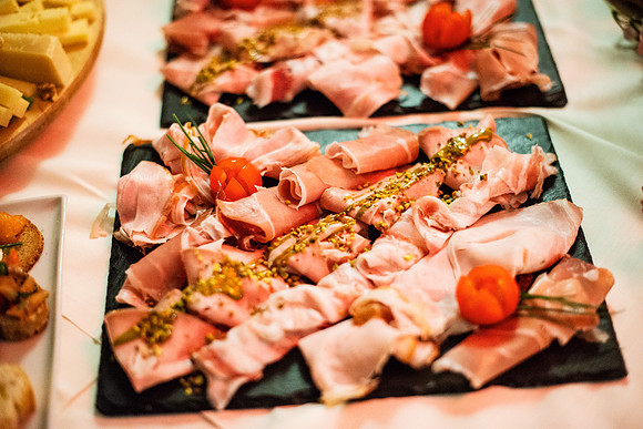 Gourmet platter featuring cured meats, garnished with herbs and